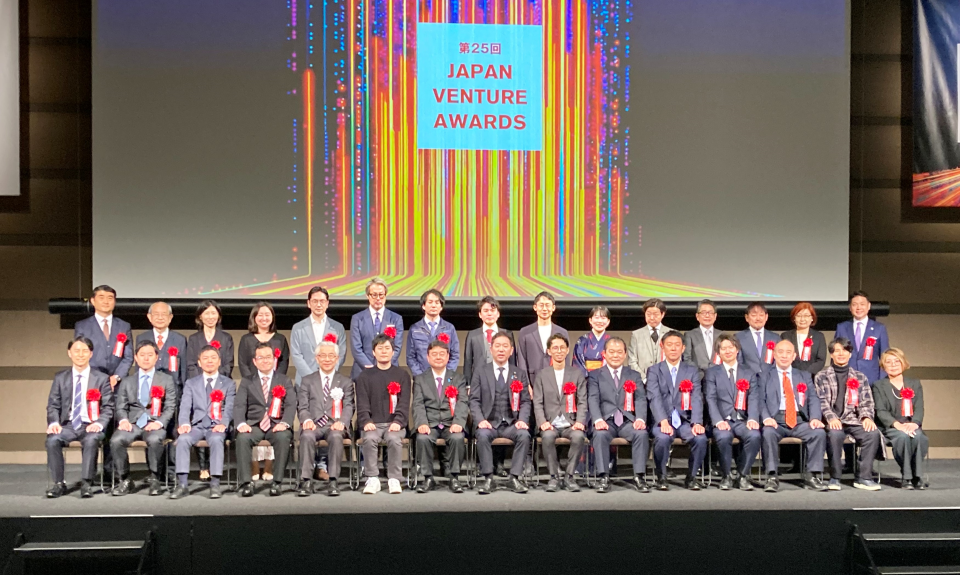 受賞者や関係者一同がステージで着席している写真