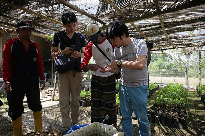 インドネシアでカカオ豆の状態を確かめる吉野慶一社長（写真右）