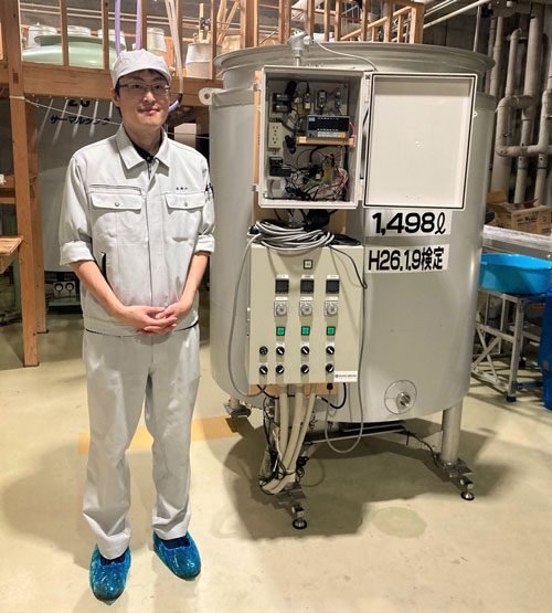 DXの実務を担当する倍賞弘平さん。右は2019年に導入した自動分析発酵タンク