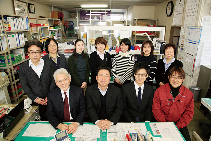 本社事務所で従業員と古賀社長（前列左端）